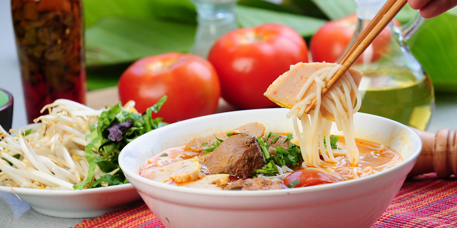 Les Plats Phare de la Cuisine Vietnamienne: le Pho, bouillon de bœuf ou de poulet, de nouilles de riz et garnie de viande et d’herbes fraîches